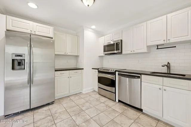 a kitchen with cabinets stainless steel appliances and sink
