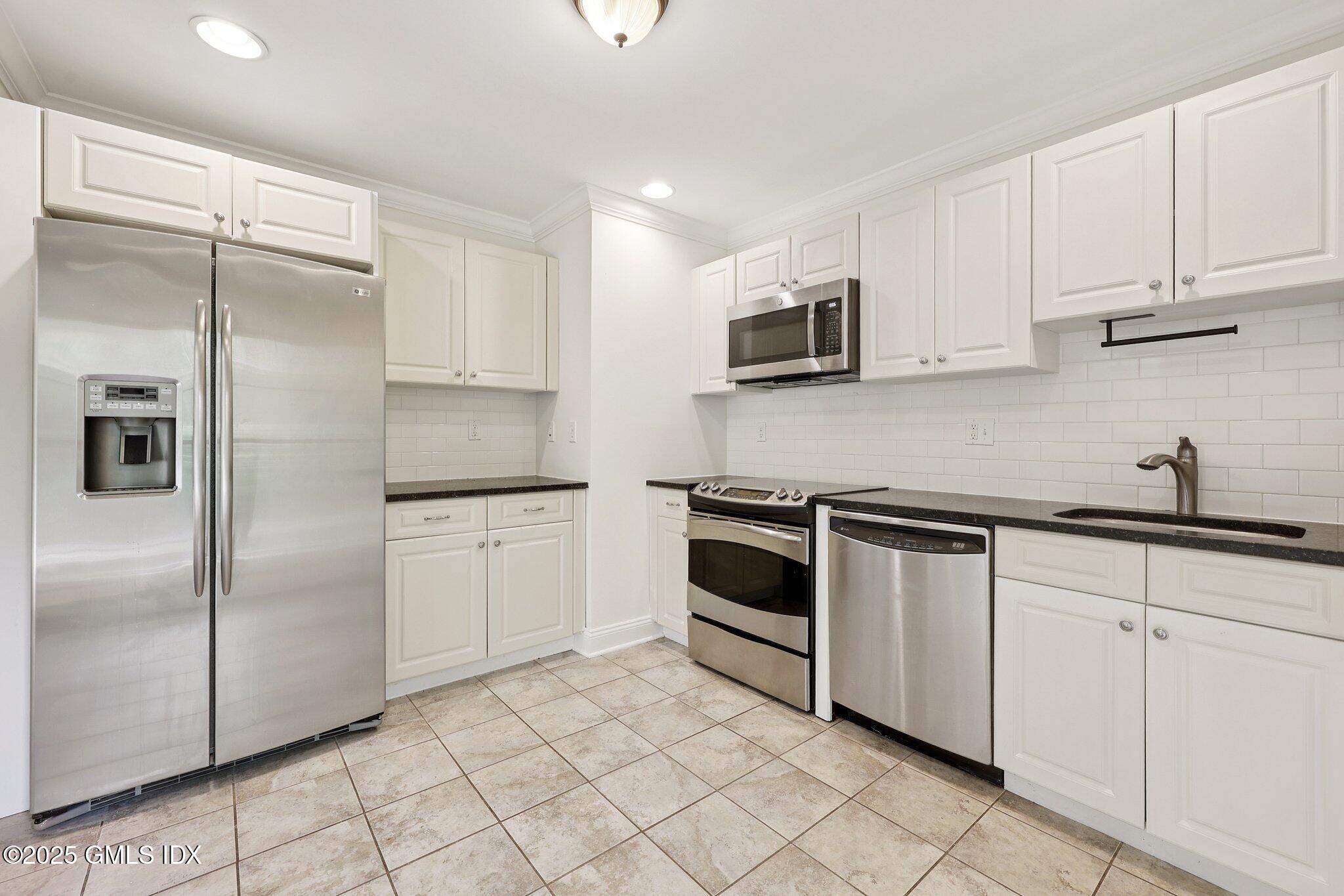 251 Weaver Street, Unit 1C Greenwich, CT 06831 - Photo 5 of 29 a kitchen with cabinets stainless steel appliances and sink