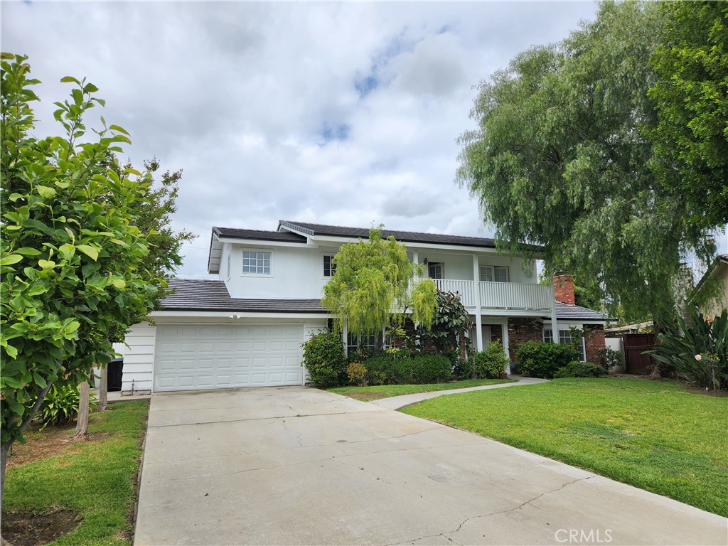 a front view of a house with a yard and trees