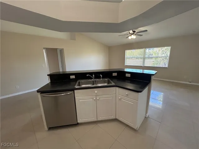 a white kitchen with a sink and a refrigerator