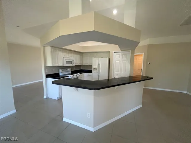a kitchen with granite countertop a sink and a stove top oven