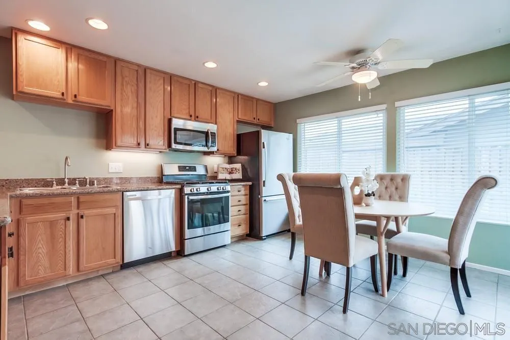 14230 Match Point Drive Poway, CA 92064 - Photo 13 of 70 a kitchen with stainless steel appliances granite countertop a stove top oven a sink dishwasher a dining table and chairs