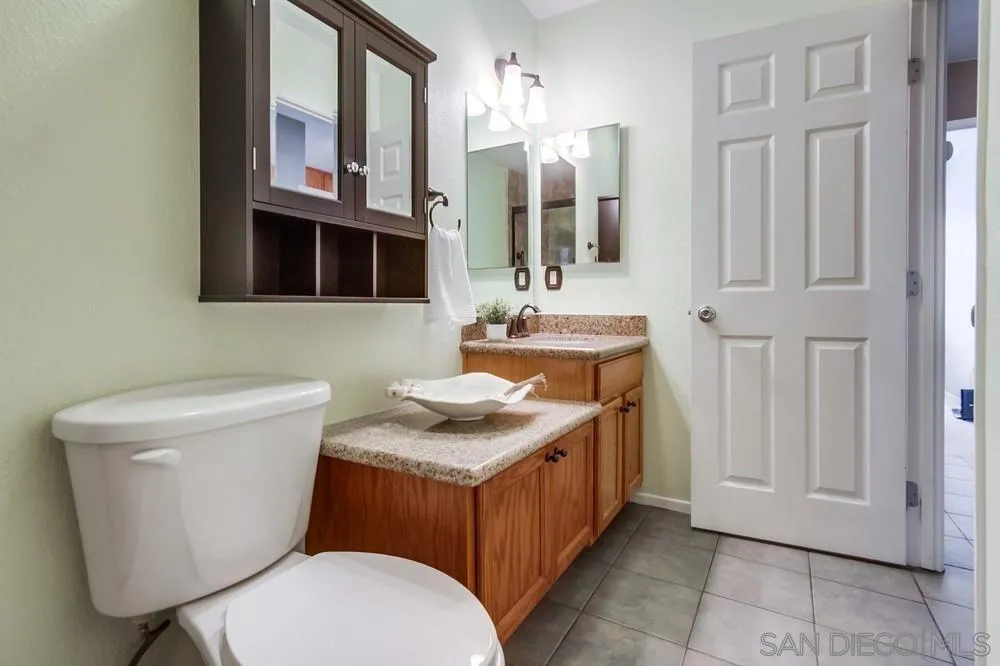 14230 Match Point Drive Poway, CA 92064 - Photo 30 of 70 a bathroom with a granite countertop toilet sink and mirror