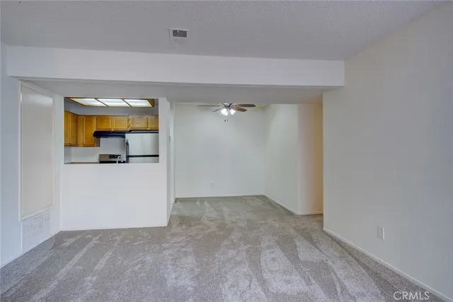 an empty room with a ceiling fan and a window