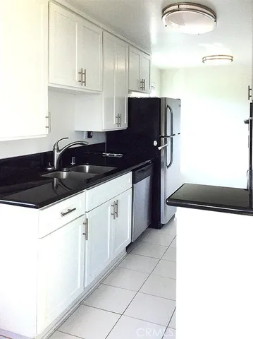 a kitchen with stainless steel appliances a sink and a refrigerator