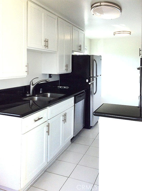 811 6th Street, Unit 305 Santa Monica, CA 90403 - Photo 12 of 25 a kitchen with stainless steel appliances a sink and a refrigerator
