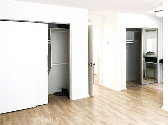 a view of an empty room with kitchen and a window