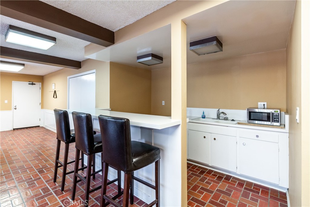 811 6th Street, Unit 305 Santa Monica, CA 90403 - Photo 24 of 25 a kitchen with a dining table chairs and white cabinets