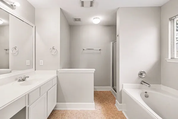 a bathroom with a tub sink and mirror