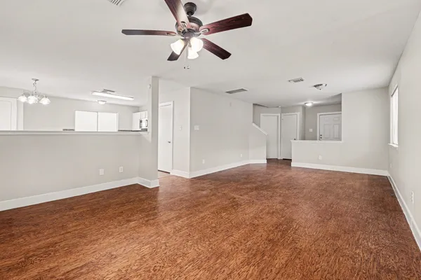 a view of an empty room and kitchen view