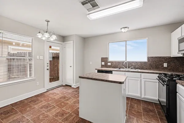 a kitchen with granite countertop a sink cabinets and window