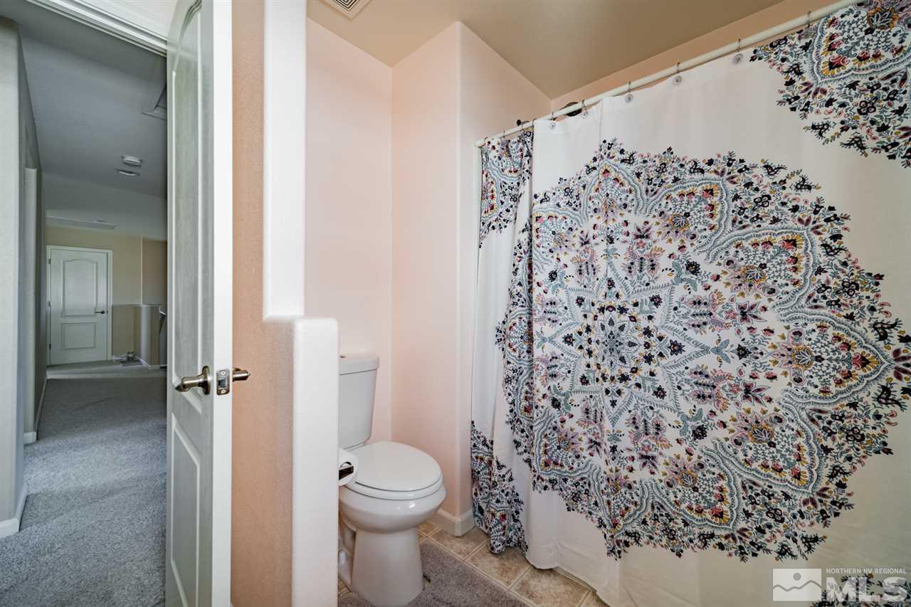 11398 Parma Court Reno, NV 89521 - Photo 22 of 39 a bathroom with a toilet and a shower curtain