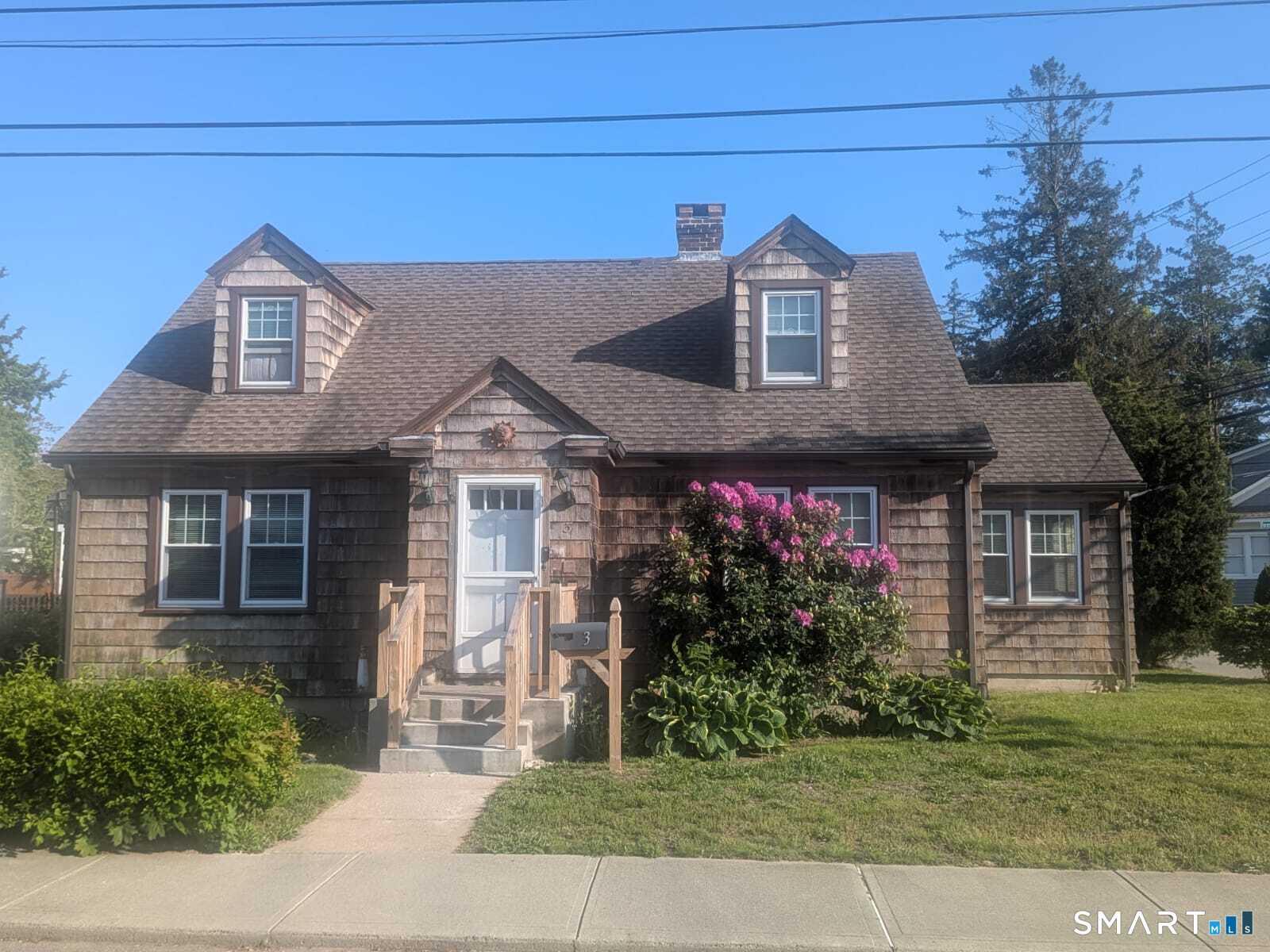 a front view of a house with a garden