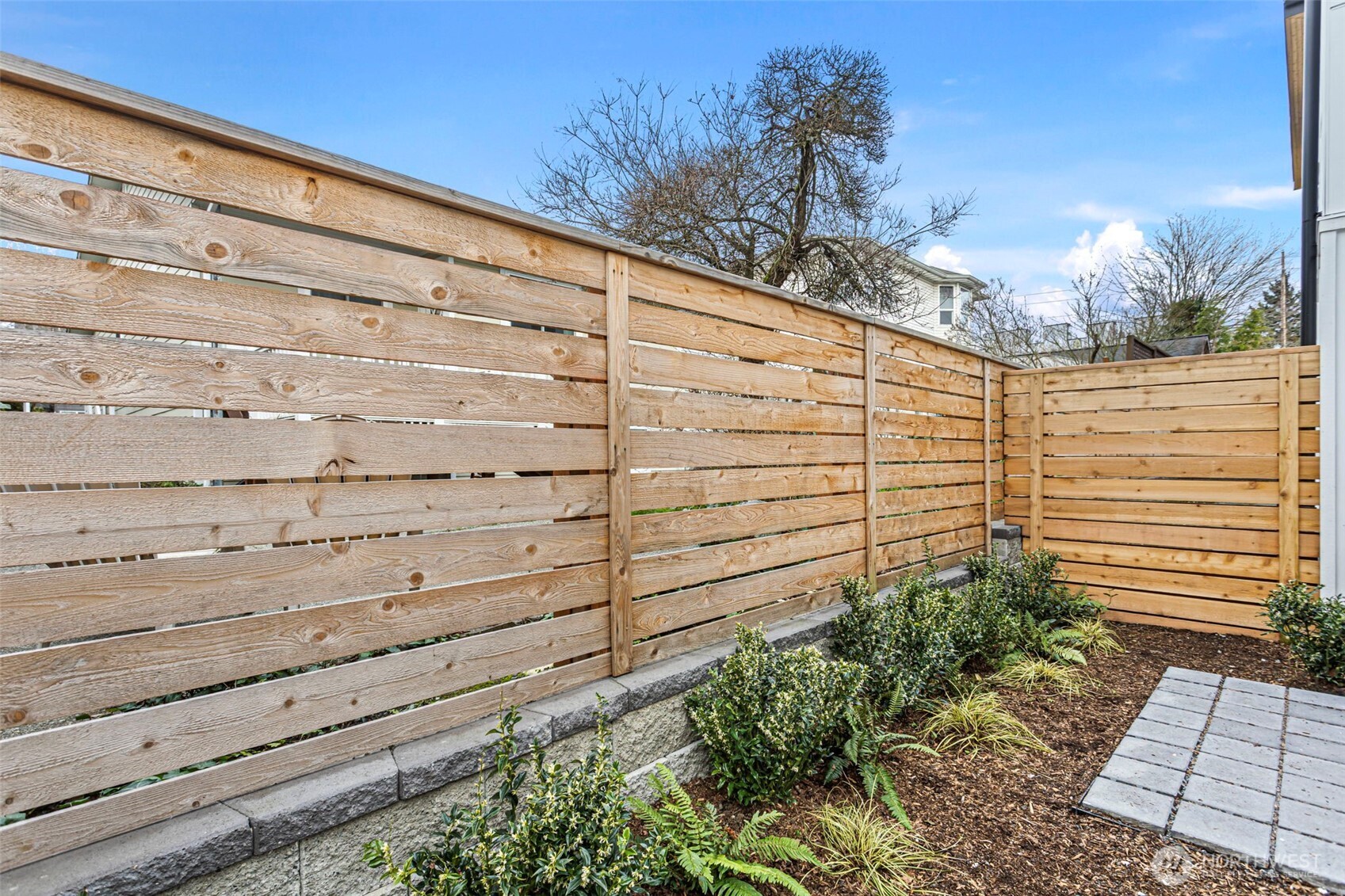 926 Northwest 57th Street, Unit B Seattle, WA 98107 - Photo 10 of 37 a view of a bunch of plants and wooden fence