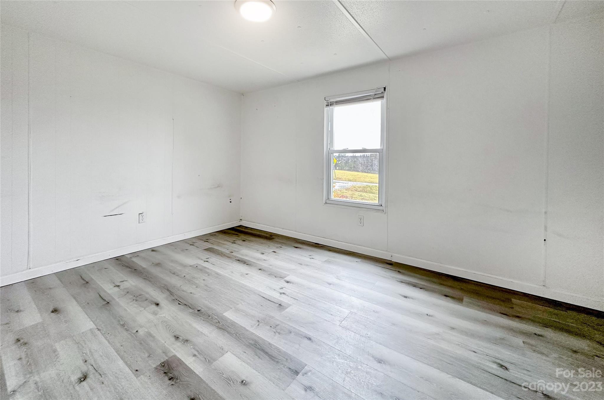 3378 Startown Road Newton, NC 28658 - Photo 13 of 30 an empty room with wooden floor and windows