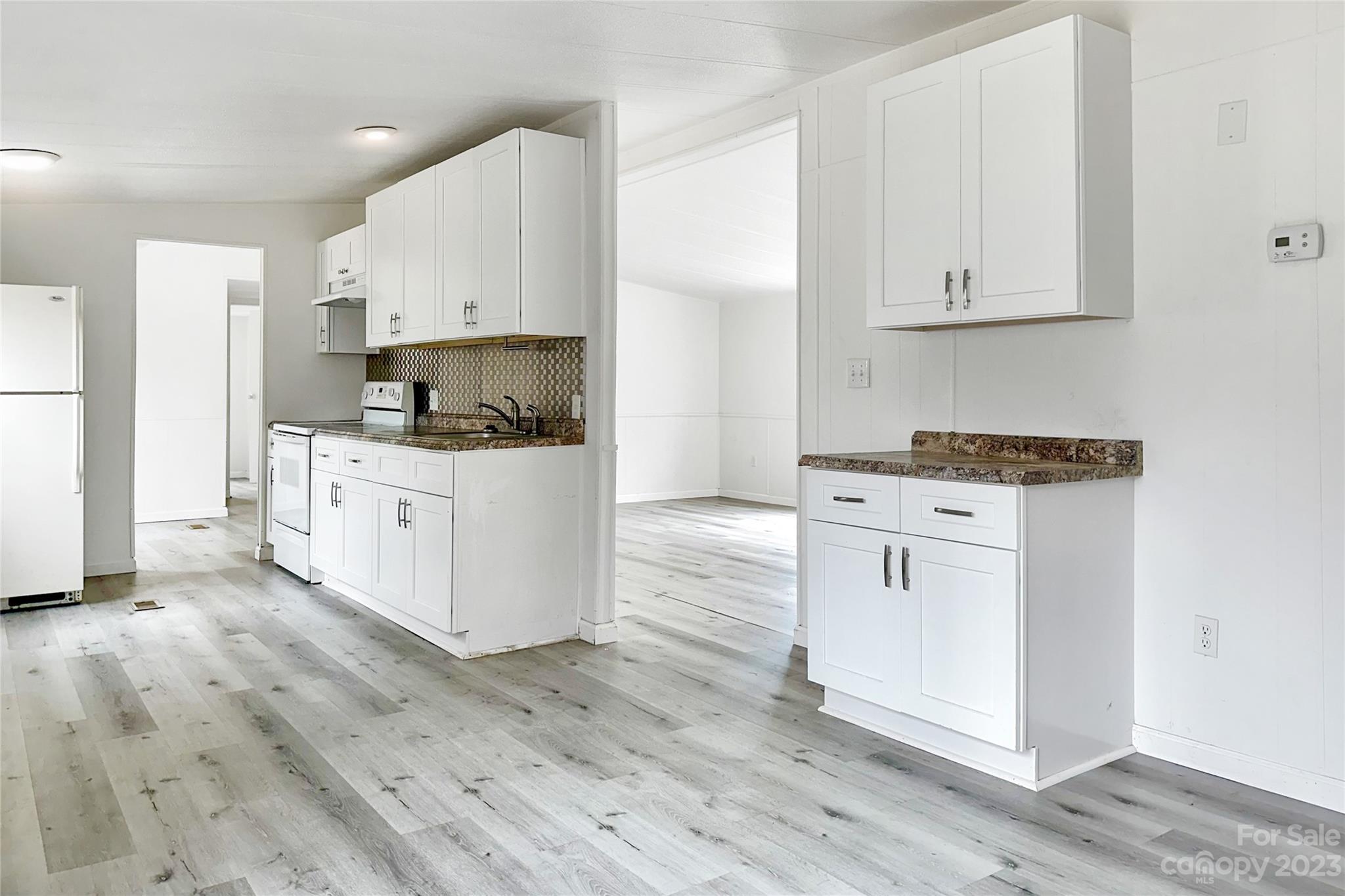 3378 Startown Road Newton, NC 28658 - Photo 8 of 30 a kitchen with granite countertop white cabinets and white appliances