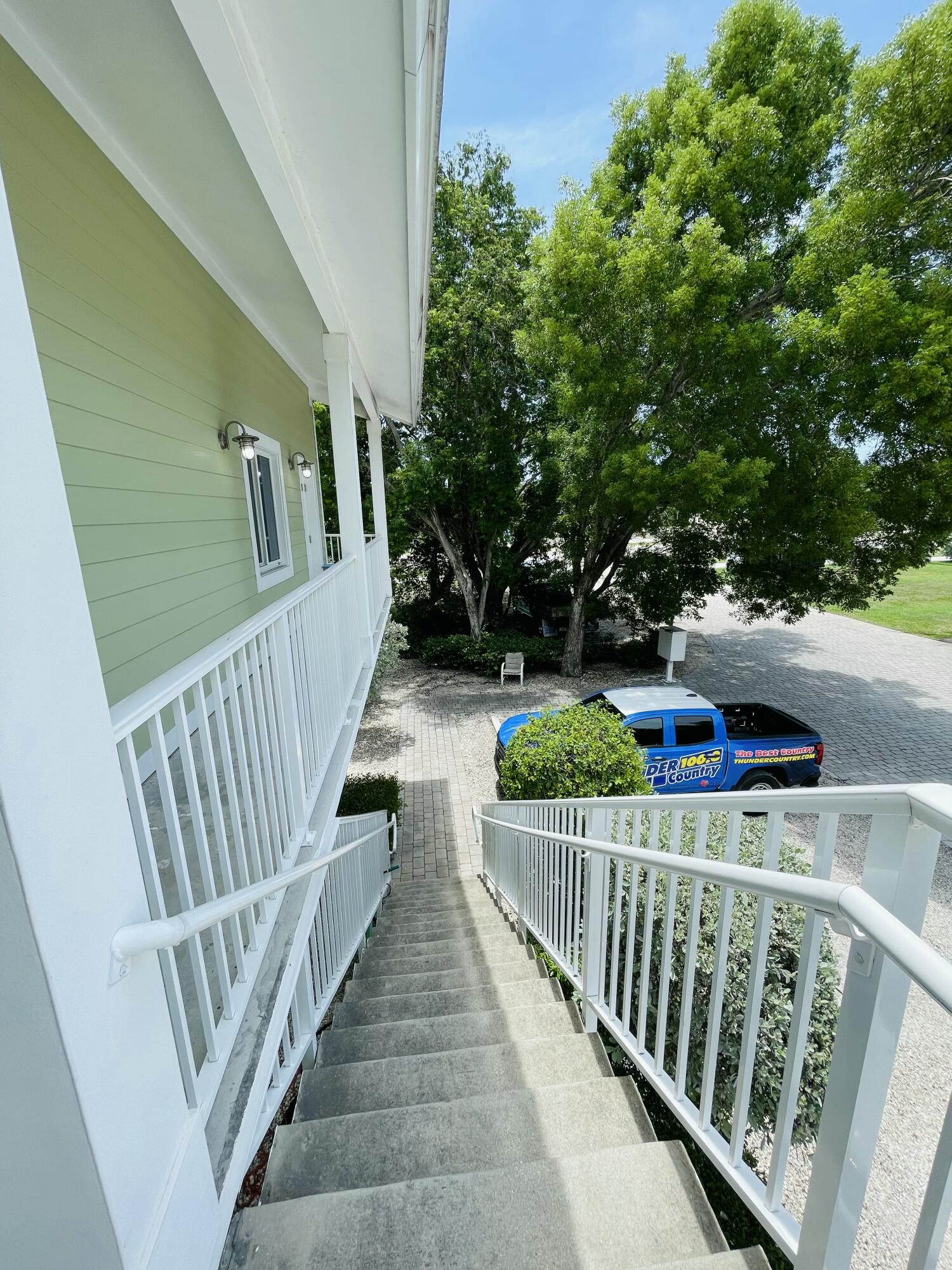 102940 Overseas Highway, Unit 2 Key Largo, FL 33037 - Photo 12 of 39 a view of a porch with wooden floor and fence