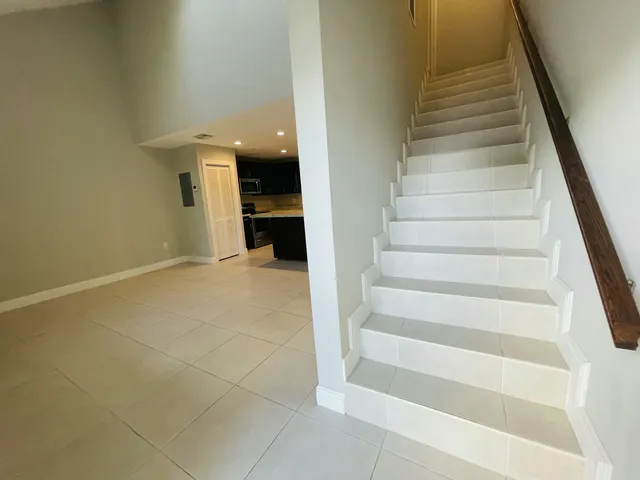 a large white kitchen with a large window and stainless steel appliances