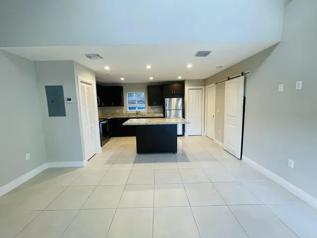 a kitchen with kitchen island granite countertop wooden cabinets a sink and a stove