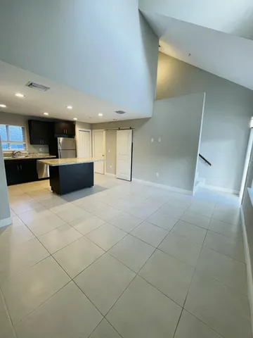 a kitchen with a refrigerator a microwave oven and a sink with wooden cabinets