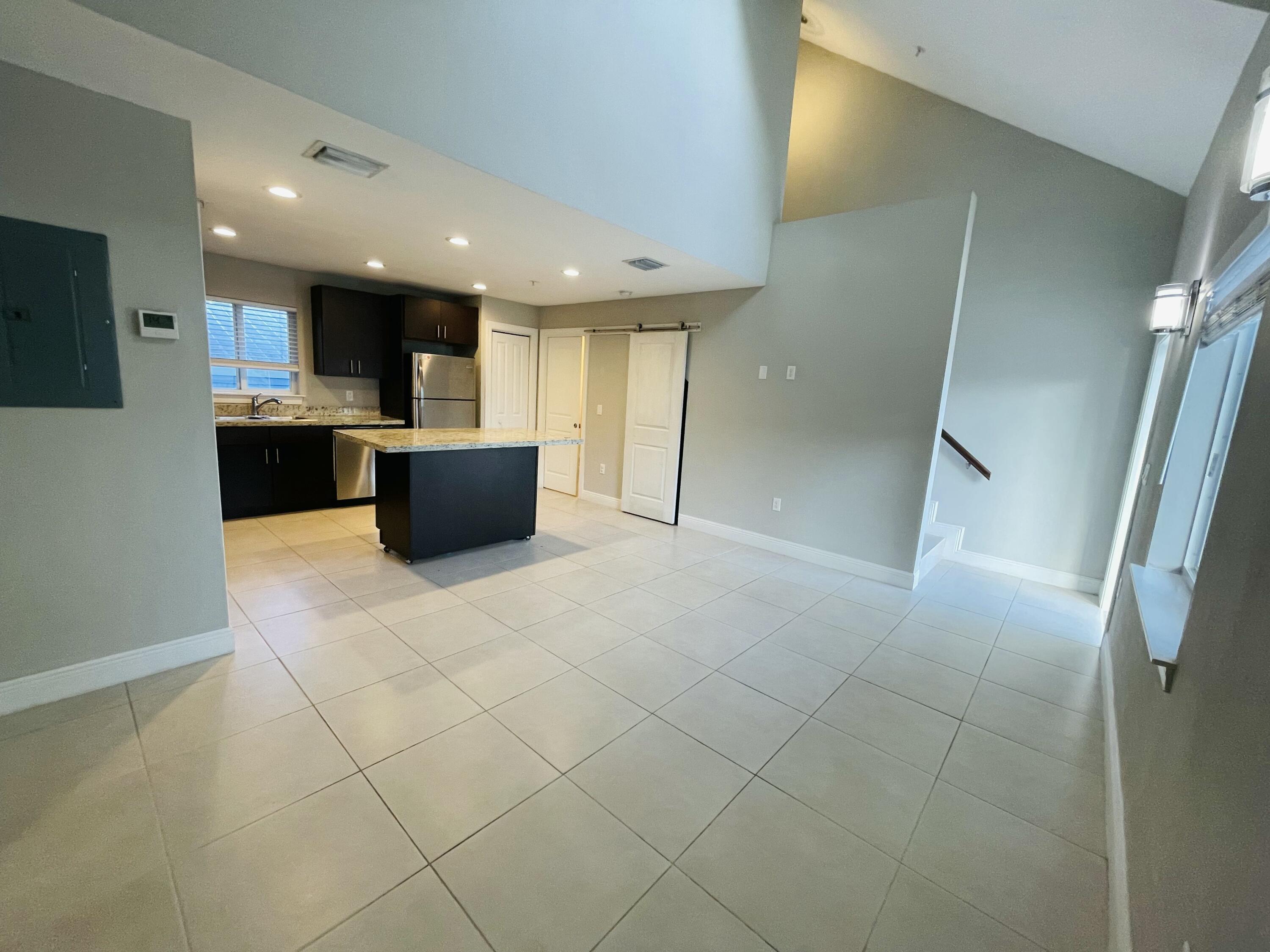 102940 Overseas Highway, Unit 2 Key Largo, FL 33037 - Photo 21 of 39 a large white kitchen with a large window and stainless steel appliances