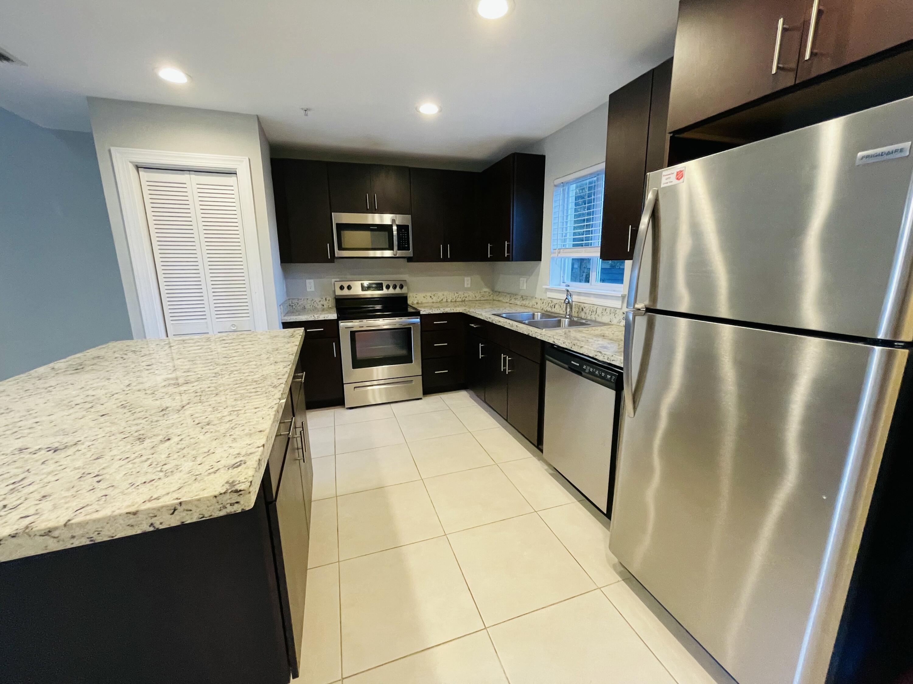 102940 Overseas Highway, Unit 2 Key Largo, FL 33037 - Photo 30 of 39 a kitchen with stainless steel appliances granite countertop refrigerator stove top oven a sink and dishwasher
