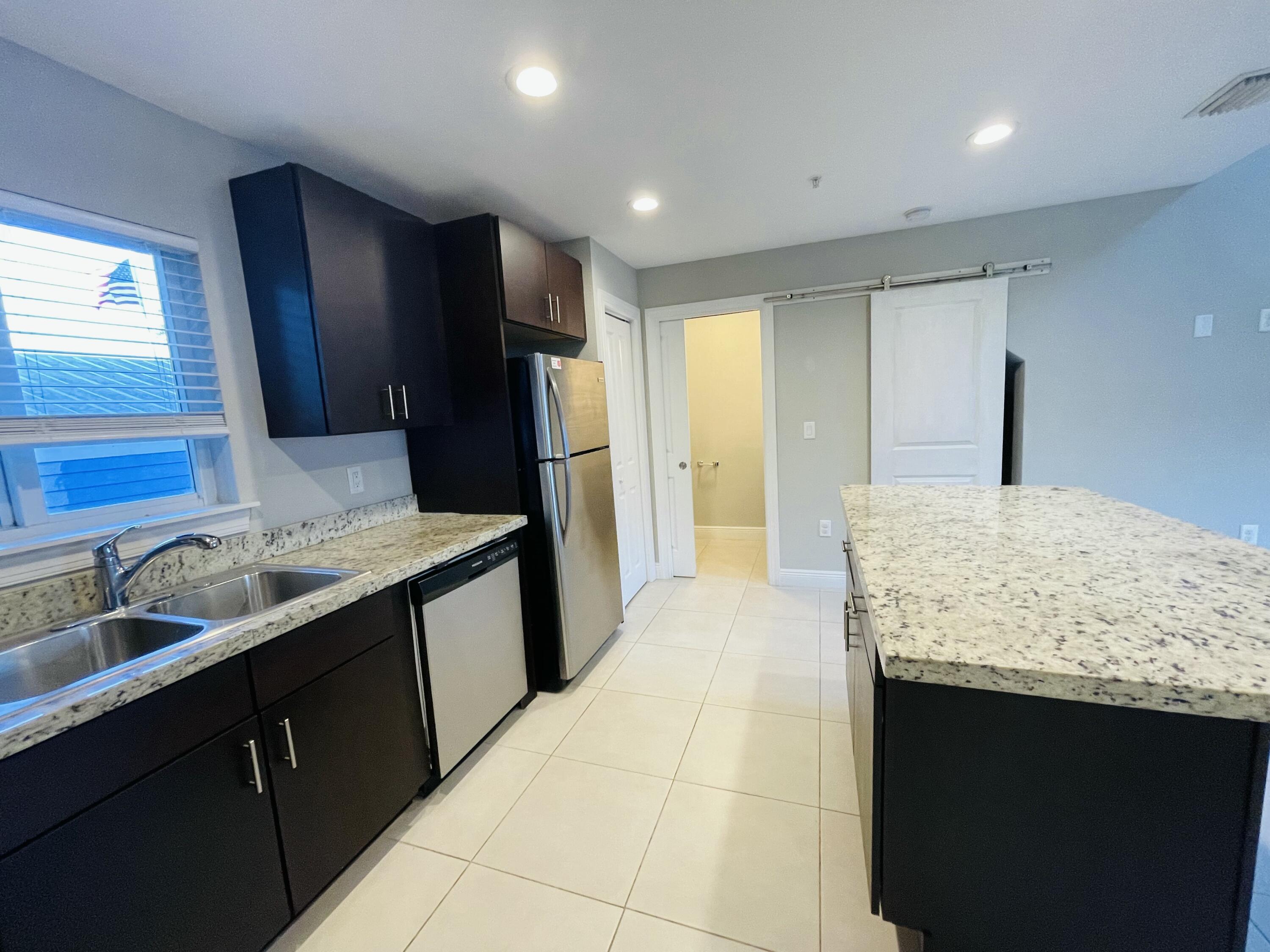 102940 Overseas Highway, Unit 2 Key Largo, FL 33037 - Photo 31 of 39 a bathroom with a granite countertop sink and a mirror