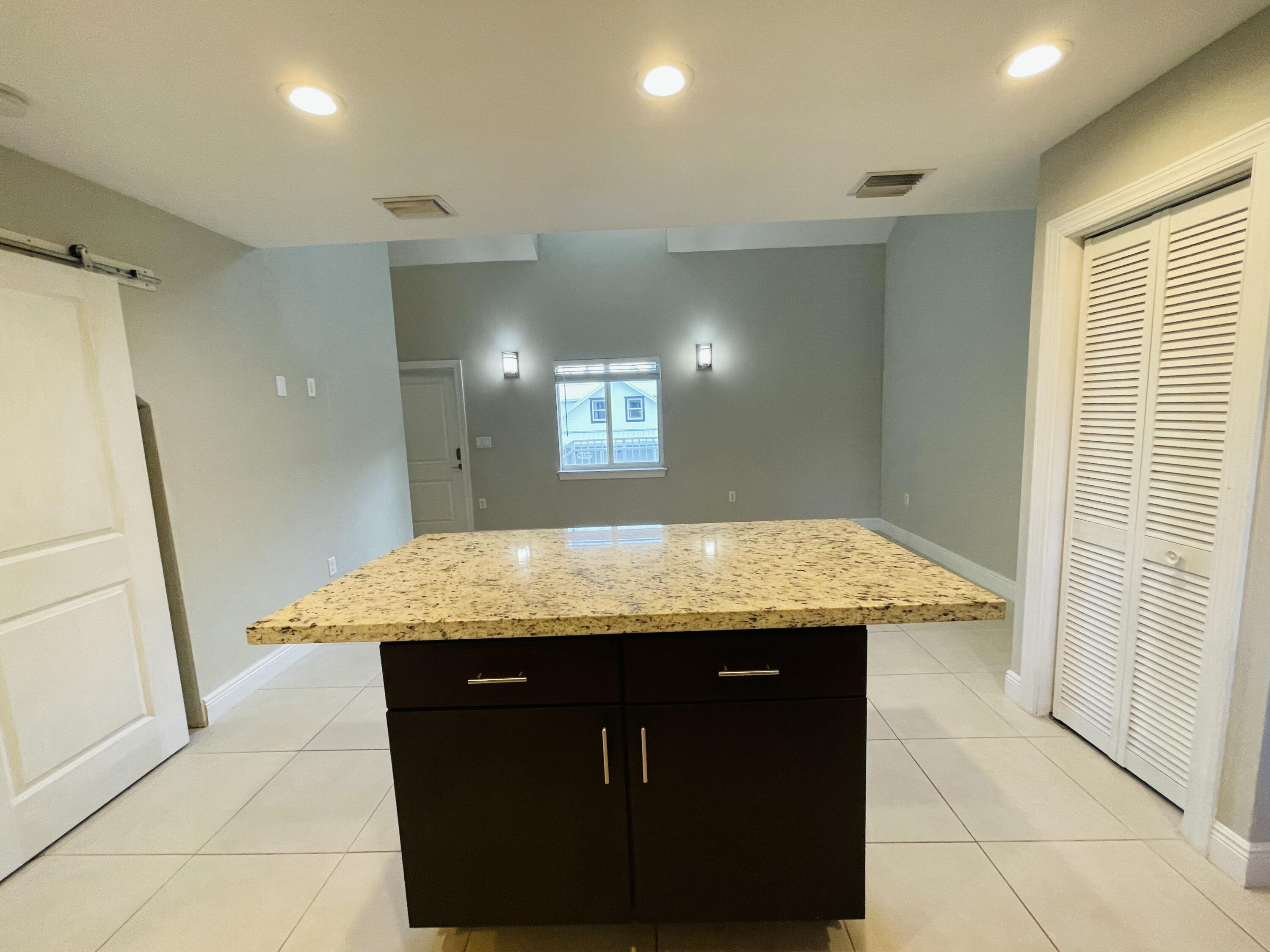 102940 Overseas Highway, Unit 2 Key Largo, FL 33037 - Photo 32 of 39 a kitchen with granite countertop a sink a counter top space and cabinets
