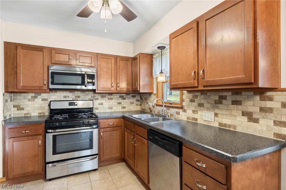 227 South Messner Road New Franklin, OH 44319 - Photo 25 of 44 Kitchen featuring tasteful backsplash, ceiling fan, stainless steel appliances, and pendant lighting