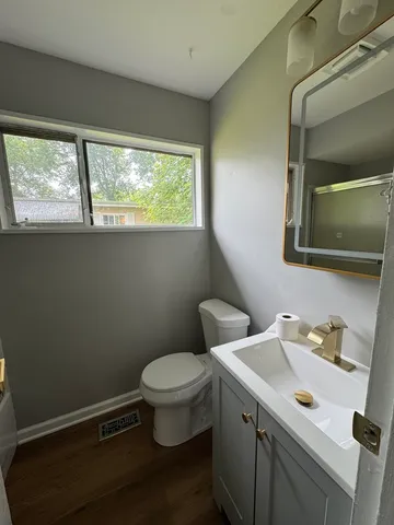 a bathroom with a sink a toilet and a window