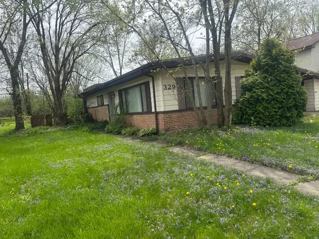 a view of a yard in front of a house with large tree