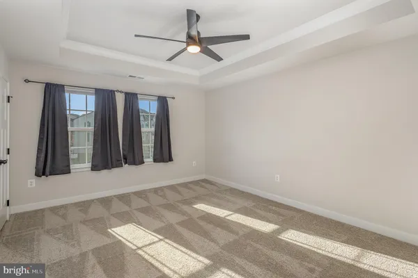 an empty room with ceiling fan and window