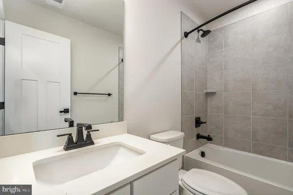 a bathroom with a sink toilet vanity and shower