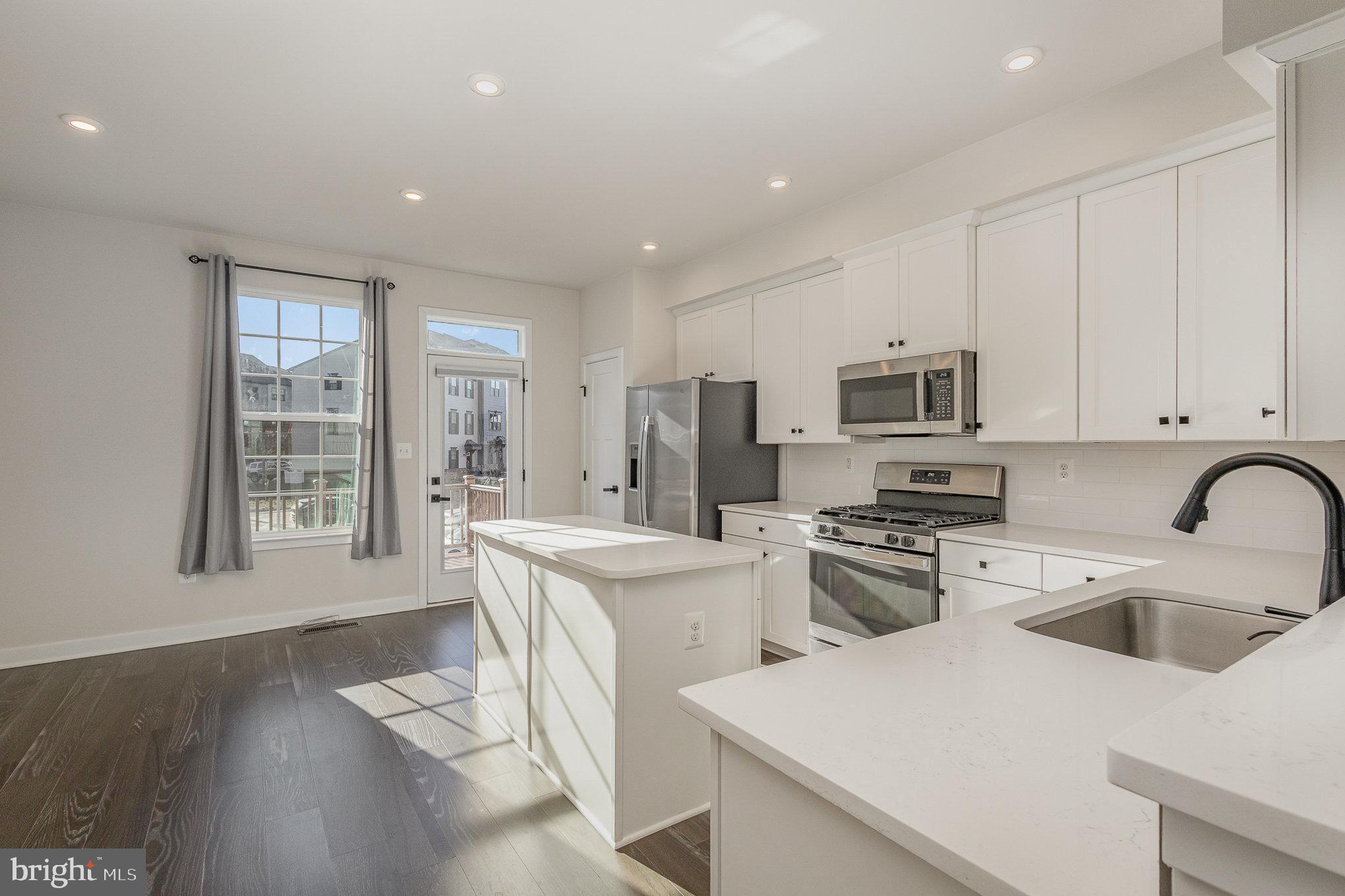 1002 Alum Spring Road Fredericksburg, VA 22401 - Photo 8 of 23 a kitchen with stainless steel appliances granite countertop a stove a sink a refrigerator and white cabinets with wooden floor
