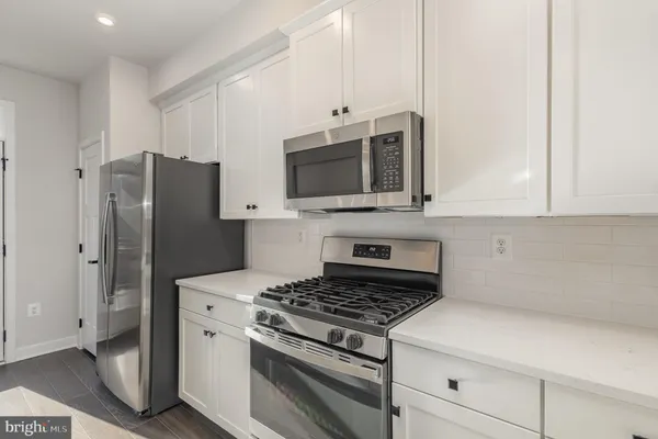 a kitchen with stainless steel appliances a refrigerator stove and microwave