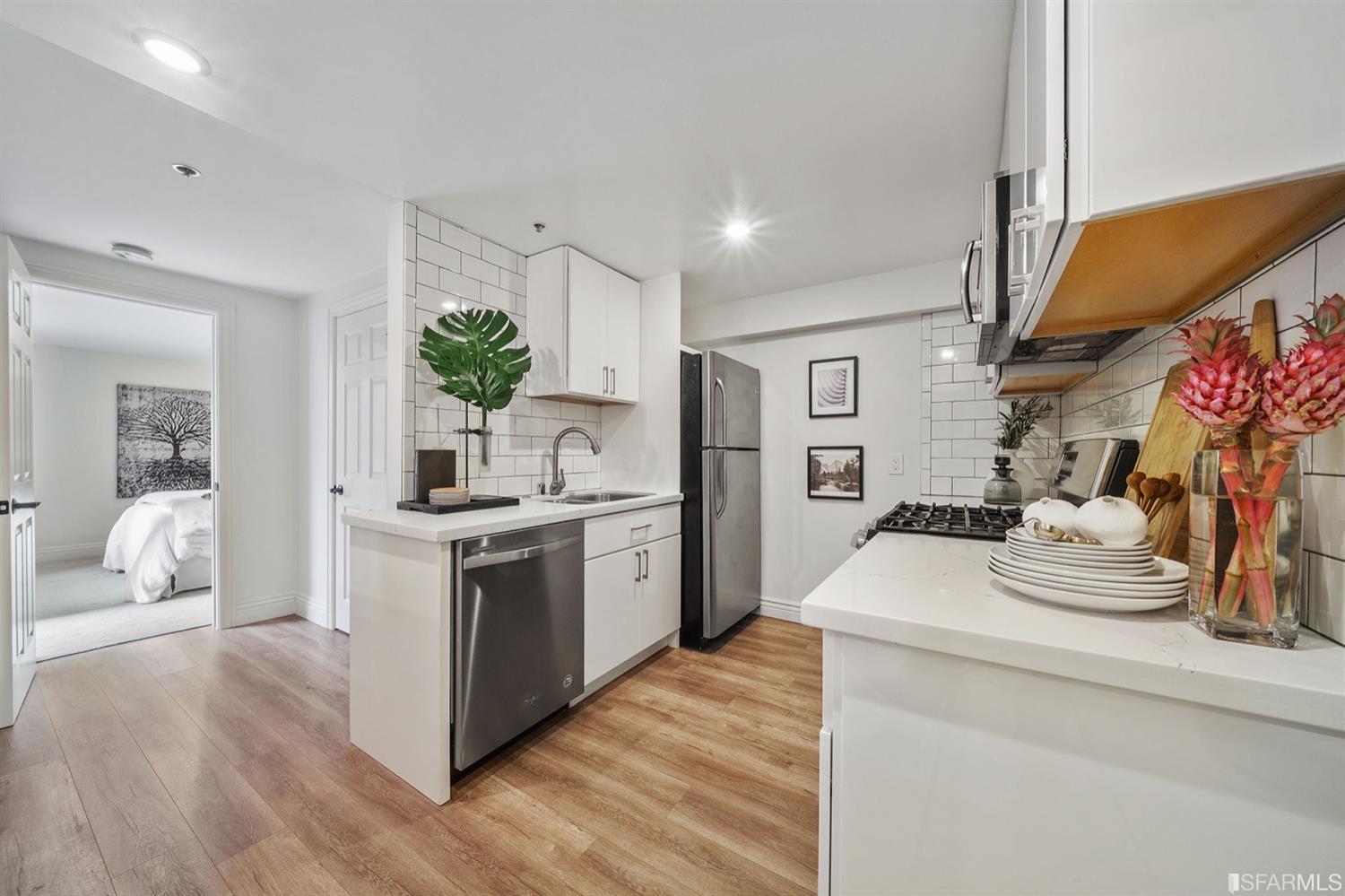 617 Broderick Street, Unit B San Francisco, CA 94117 - Photo 24 of 36 a kitchen with stainless steel appliances kitchen island hardwood floor sink stove and wooden cabinets