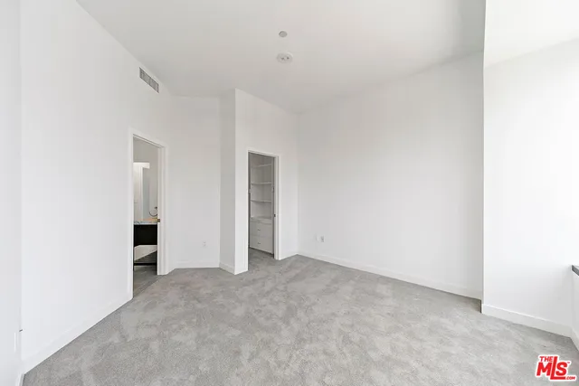 a view of an empty room with closet and entryway
