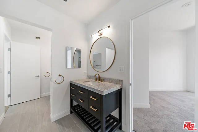 a bathroom with a granite countertop sink a mirror and a vanity