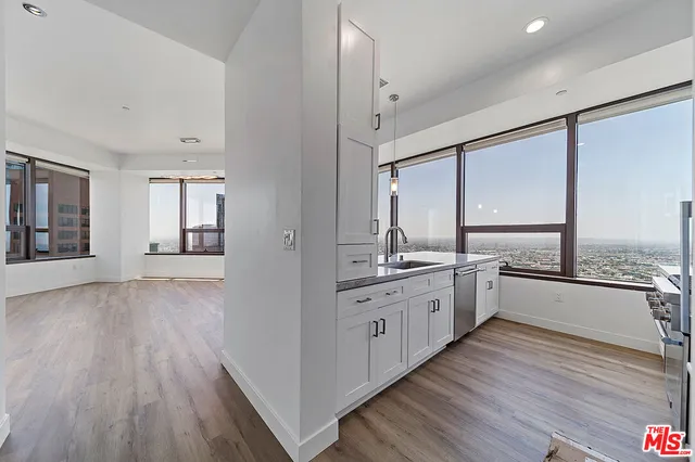 a large kitchen with a lot of counter space and wooden floor