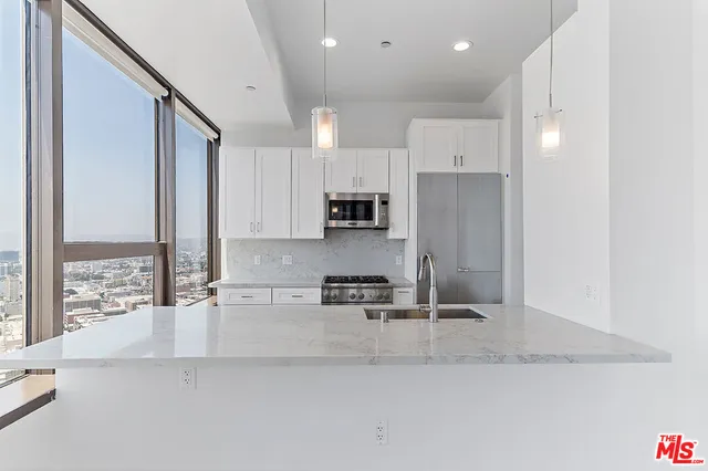 a kitchen with stainless steel appliances granite countertop a sink refrigerator and cabinets