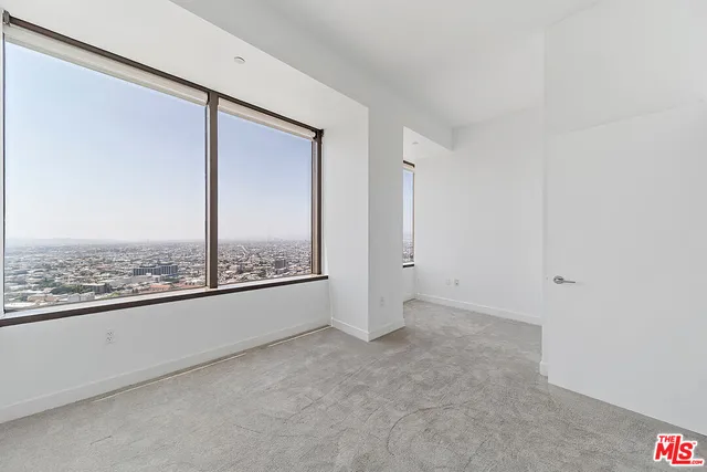 an empty room with a view of city from balcony