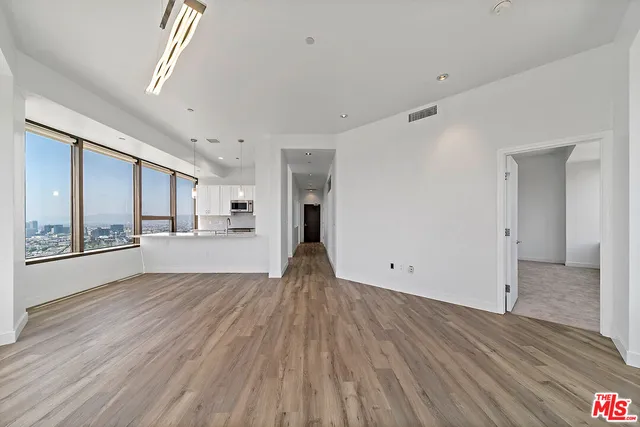 a view of empty room with wooden floor and window