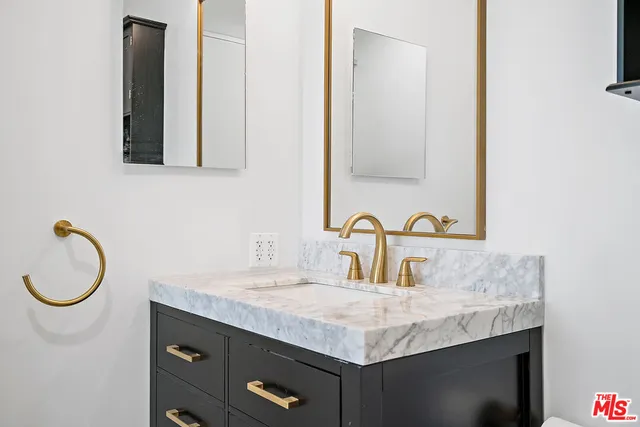 a bathroom with a granite countertop sink and a mirror