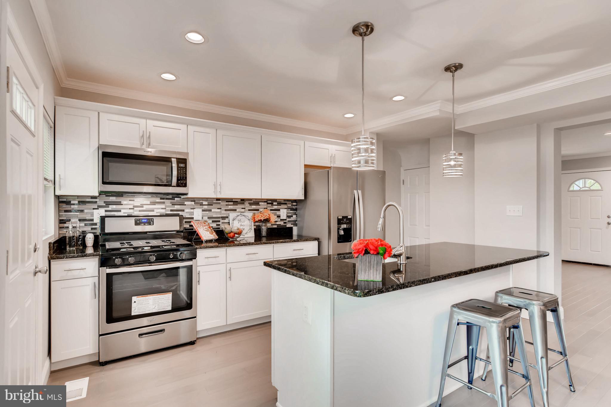 1315 Silverthorne Road Baltimore, MD 21239 - Photo 2 of 28 a kitchen with stainless steel appliances a stove a sink island and a refrigerator