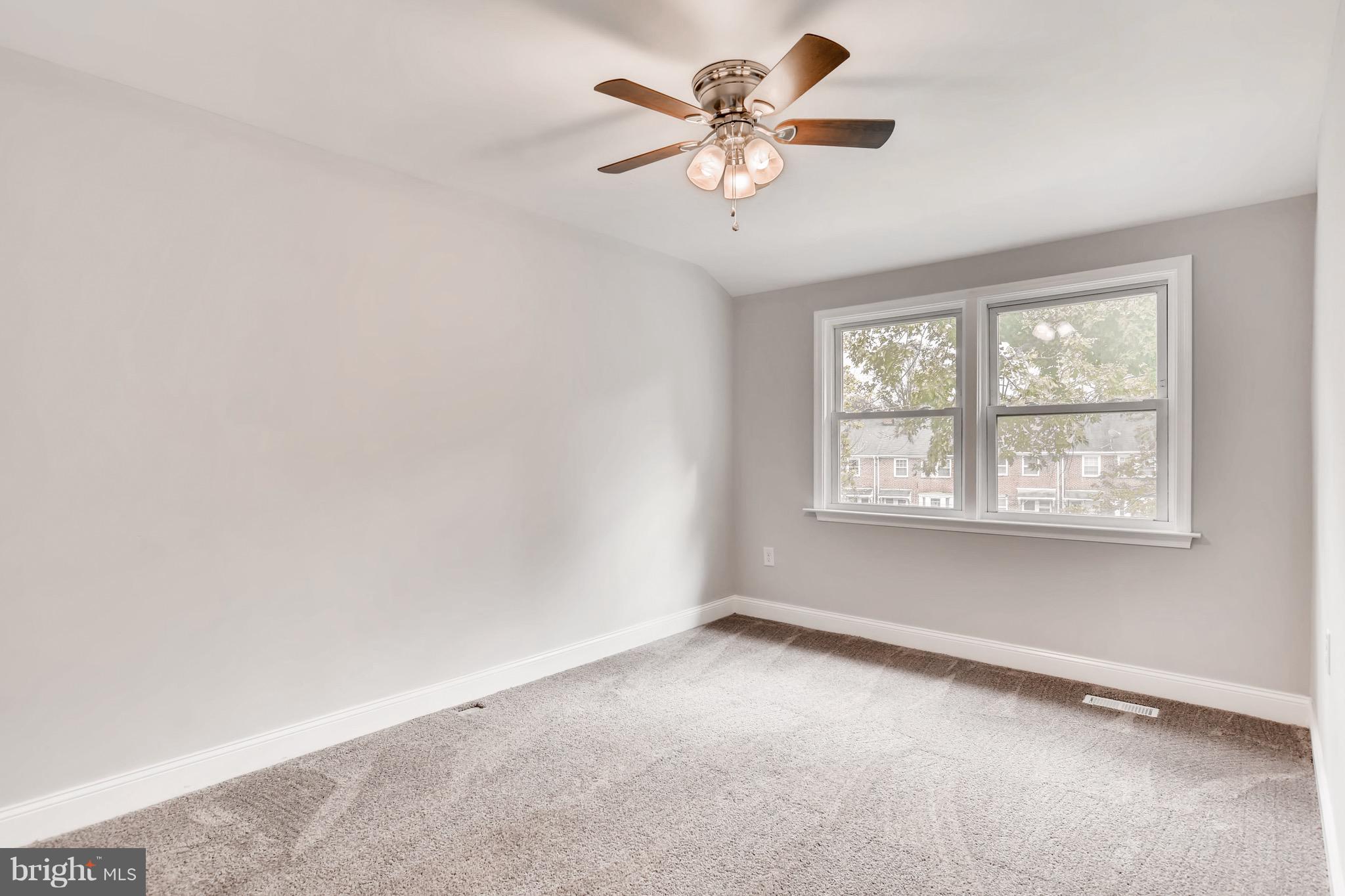 1315 Silverthorne Road Baltimore, MD 21239 - Photo 16 of 28 an empty room with a window and a fan