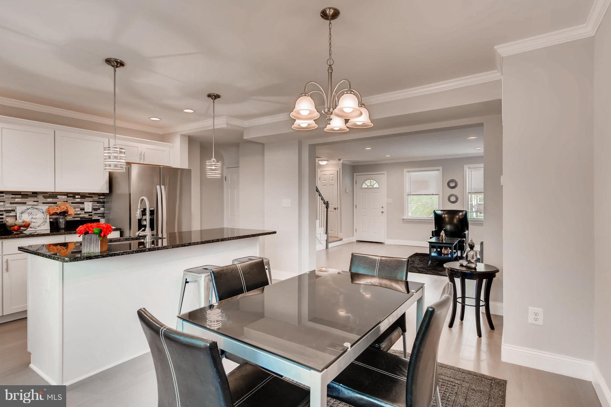 1315 Silverthorne Road Baltimore, MD 21239 - Photo 3 of 28 a view of a dining room and livingroom with furniture wooden floor a chandelier