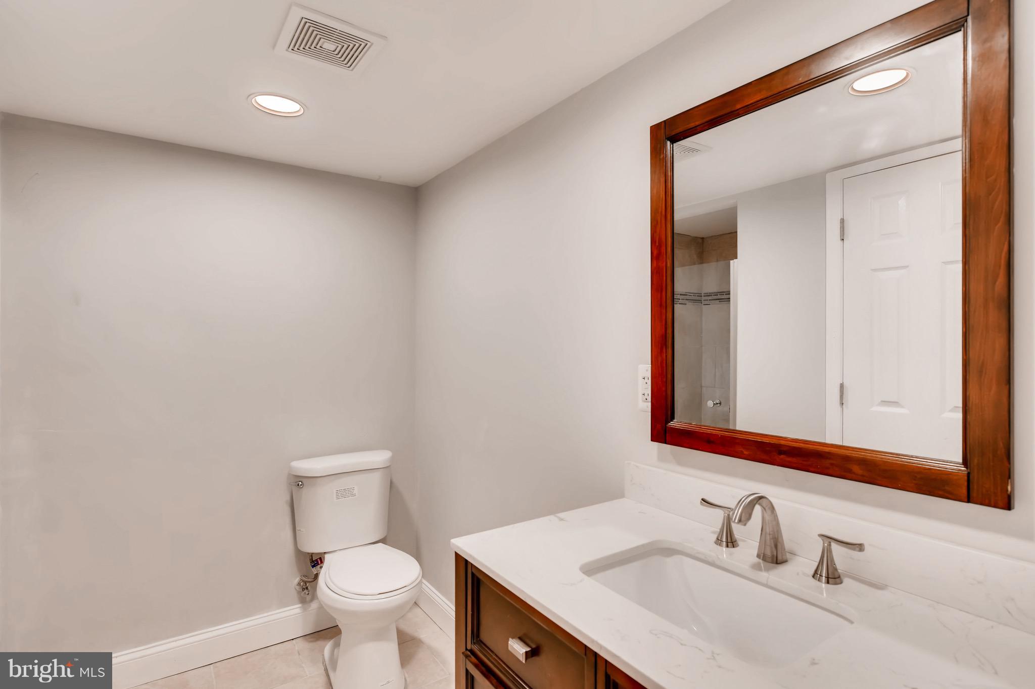 1315 Silverthorne Road Baltimore, MD 21239 - Photo 21 of 28 a bathroom with a sink vanity mirror and toilet
