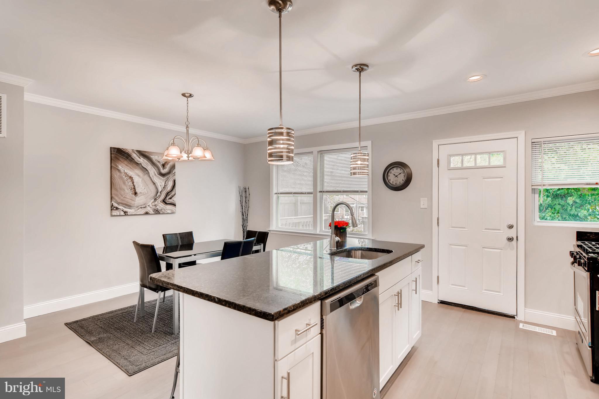 1315 Silverthorne Road Baltimore, MD 21239 - Photo 4 of 28 a kitchen with a table a refrigerator and cabinets