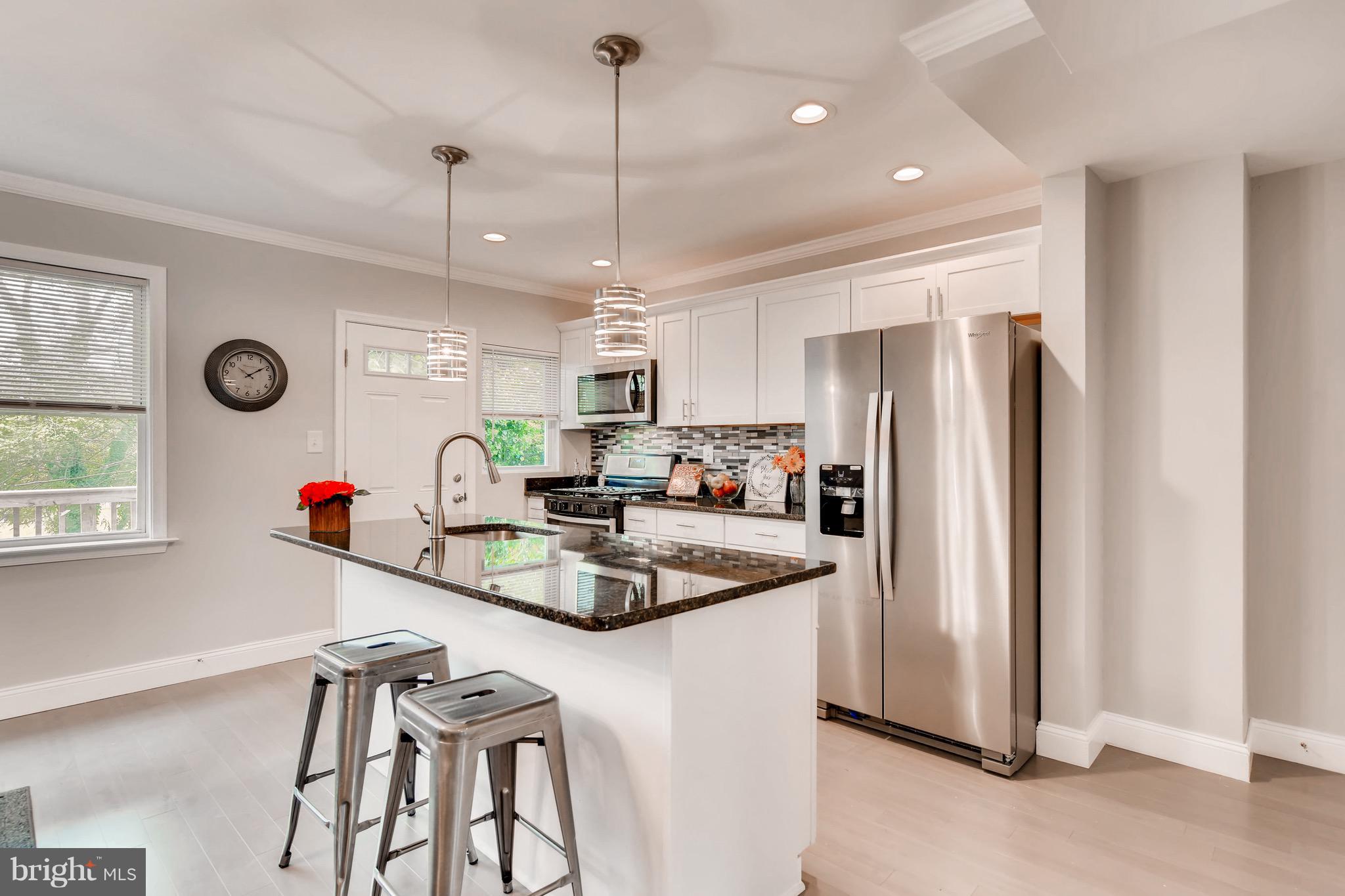 1315 Silverthorne Road Baltimore, MD 21239 - Photo 5 of 28 a kitchen that has a lot of furniture a refrigerator and a table