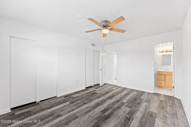 a view of a room with wooden floor and white walls
